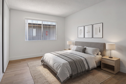 A bedroom with a large bed and a window with bars.