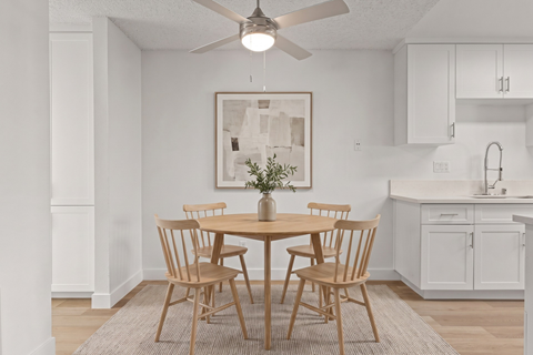 A dining room with a table and chairs.