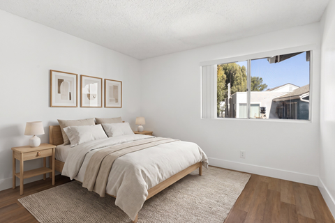 A bedroom with a large bed and two nightstands.