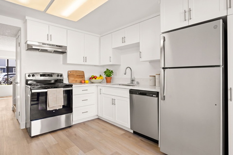 A modern kitchen with a stainless steel refrigerator and oven.