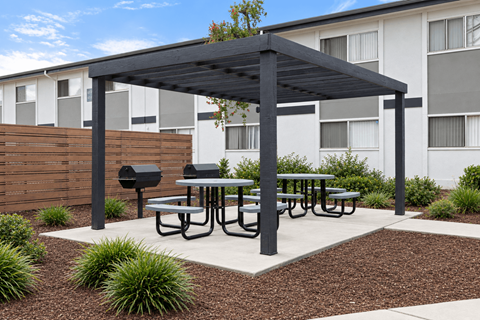 A black pergola is over a picnic table.