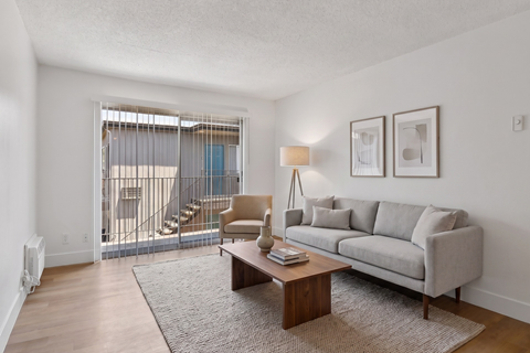 A living room with a grey couch, a brown coffee table, and a lamp.