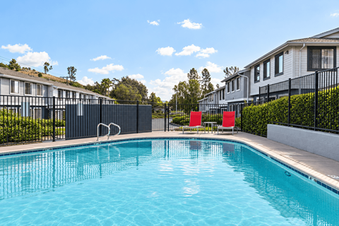 A swimming pool in front of a row of houses.