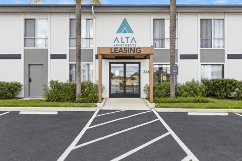 The Alta Apartments Leasing office is located in front of a white building with a palm tree.