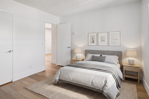 A bedroom with a large bed and two nightstands.