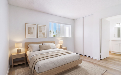 A bedroom with a large bed and two nightstands.
