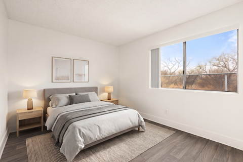 A bedroom with a large bed and two lamps on side tables.