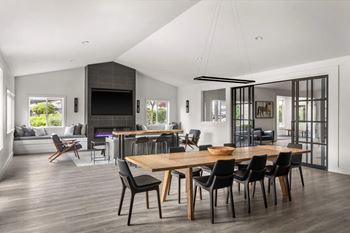 A modern dining room with a wooden table and chairs.