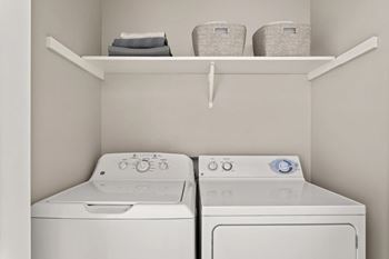 Two white washing machines in a laundry room.