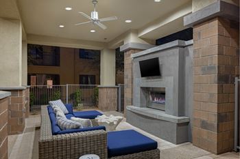 A patio with a fireplace and seating area.