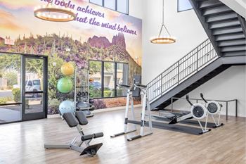 A gym with a staircase and exercise equipment.