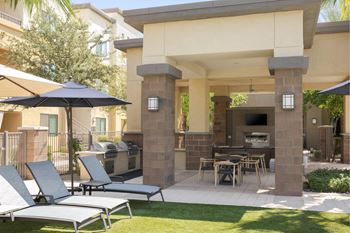 A patio with a table, chairs and an umbrella.