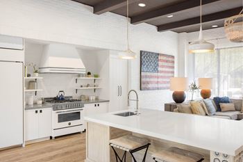 A modern kitchen with a large island and pendant lights.