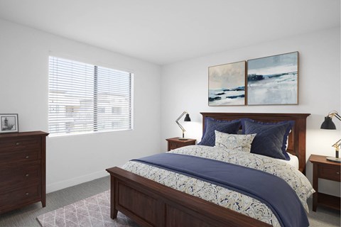 A bedroom with a large bed and two lamps.