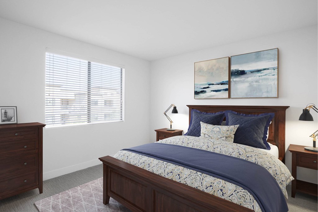 A bedroom with a large bed and two lamps.