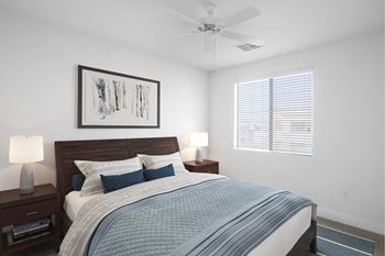 A bedroom with a bed, nightstands, and a ceiling fan.