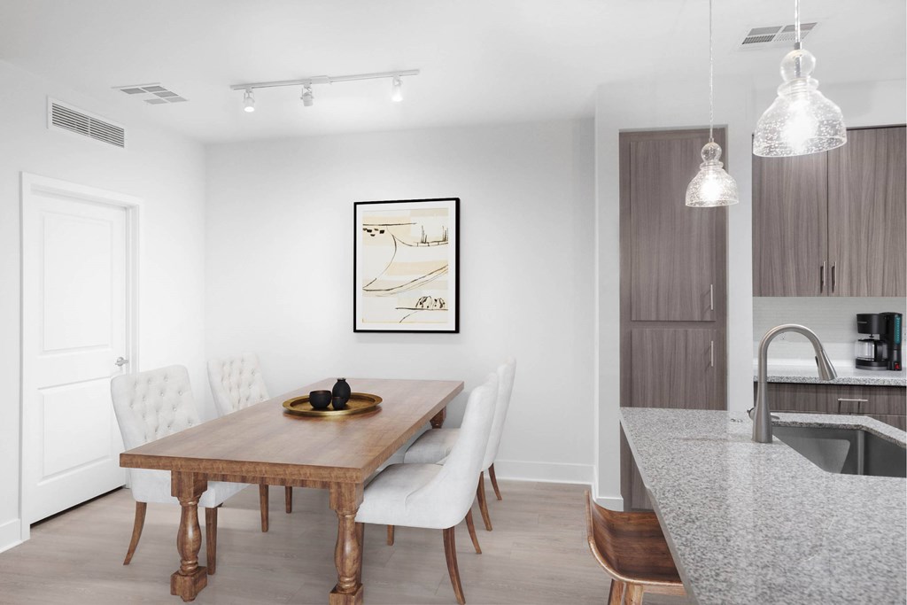 A modern dining room with a wooden table and white chairs.