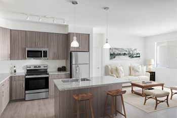 A modern kitchen with a large island and a dining area.