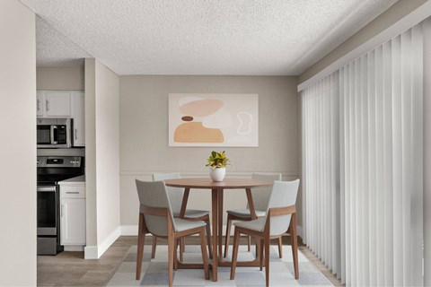 A dining room with a table and chairs.