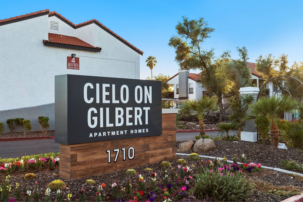 A sign for Cielo on Gilbert Apartment Homes stands in front of a building.
