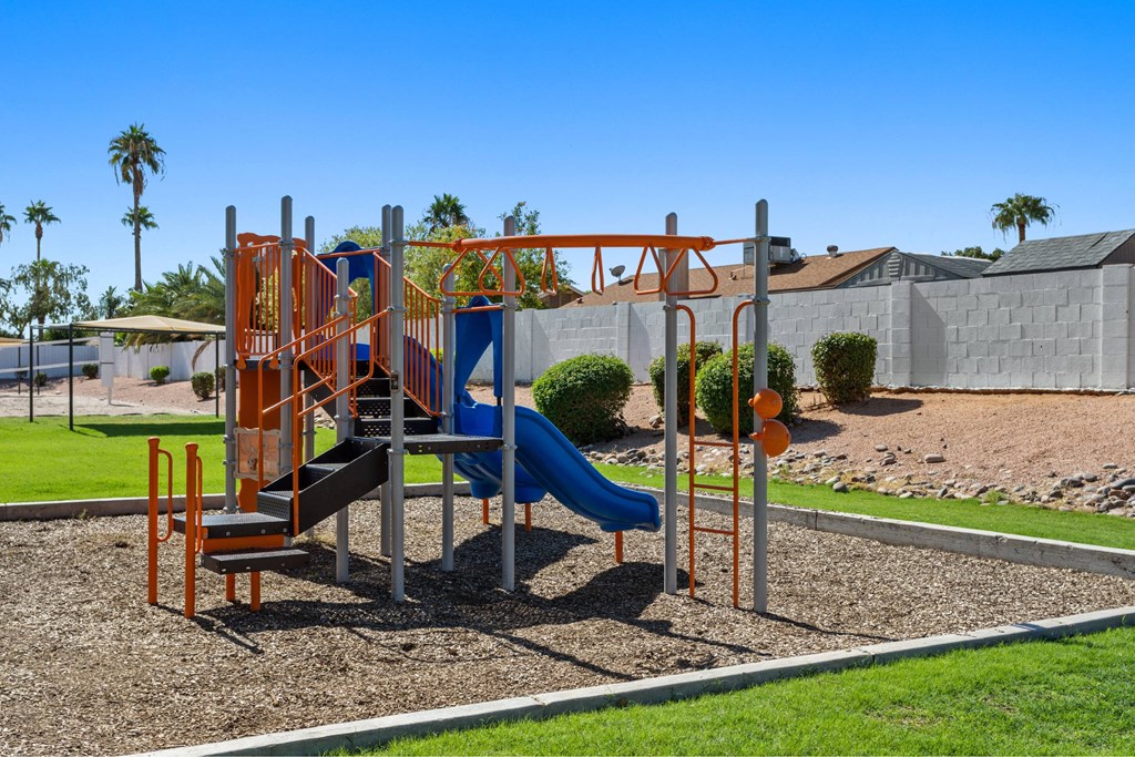 A playground with a blue slide and orange climbing structure.
