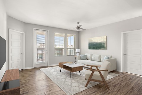 A living room with a white couch, a wooden coffee table, and a painting on the wall.