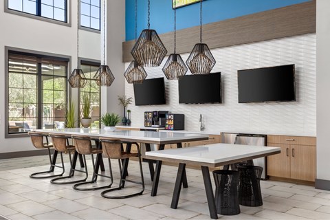 A modern dining room with a long table and chairs.