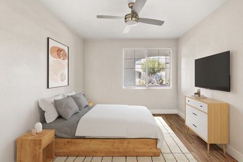 A bedroom with a bed, nightstand, and a television.