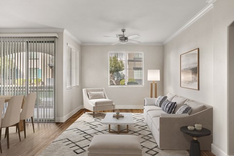 A living room with a white couch, a chair, a coffee table, and a painting on the wall.
