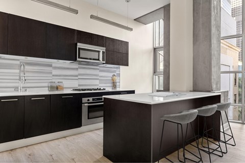 A modern kitchen with dark wood cabinets and a white countertop.