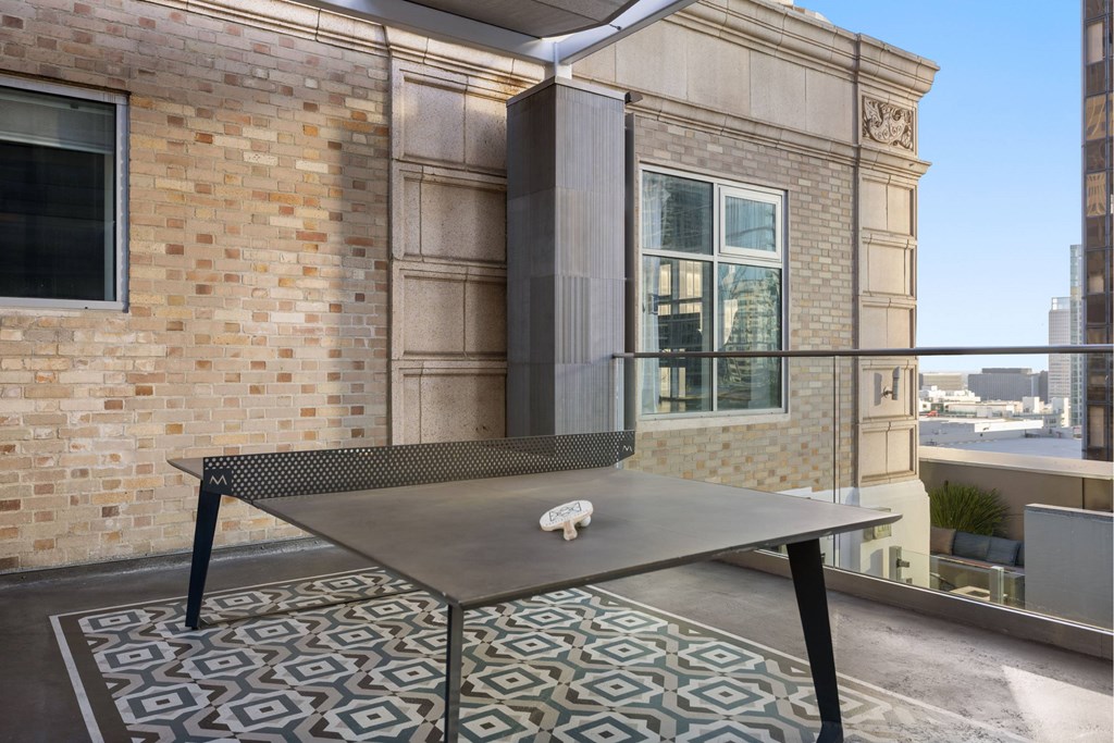 A ping pong table with a white paddle and ball on it.