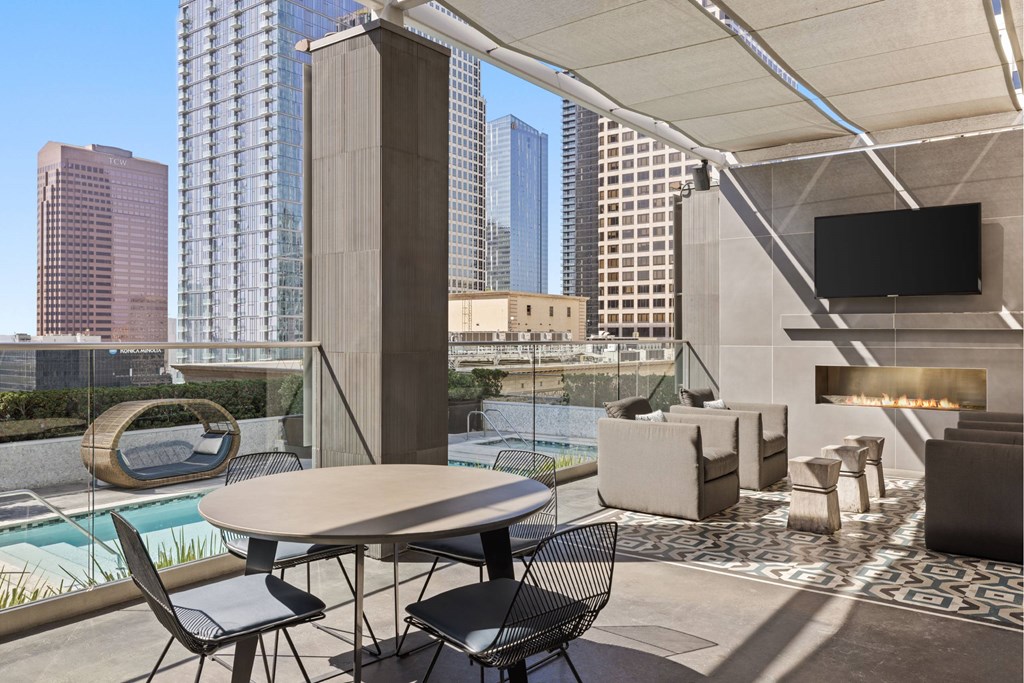 A modern balcony with a table and chairs overlooking a cityscape.