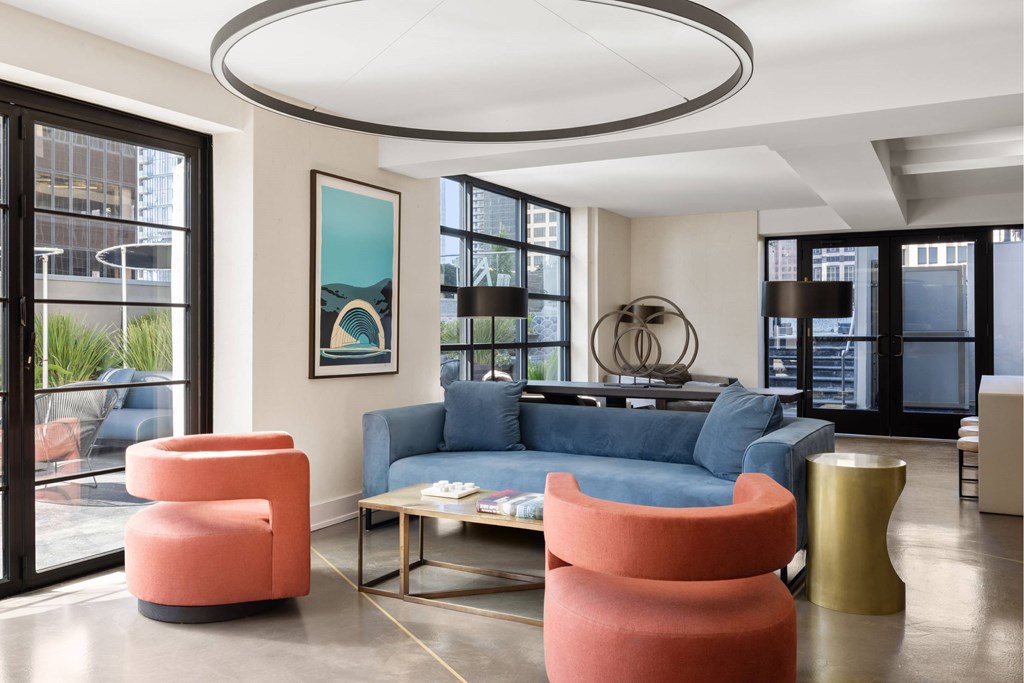 A living room with a blue couch and orange chairs.