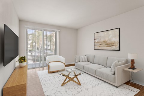 A living room with a grey couch, a wooden table, and a painting on the wall.