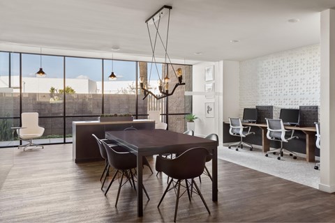 A modern dining room with a large table and chairs.