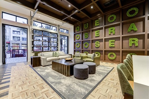 A living room with a green chair and a wreath on the wall.