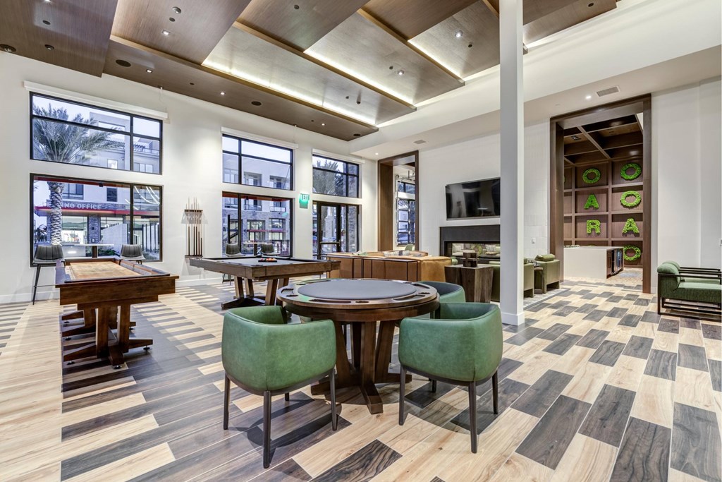A modern dining room with a round table surrounded by green chairs.
