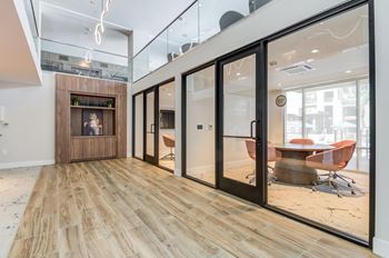 A modern office space with a wooden floor and glass walls.