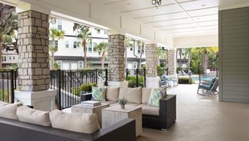 A patio with a black railing and a white couch.