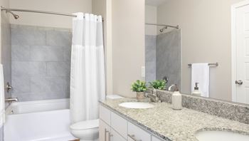 A bathroom with a white tub, sink, and toilet.