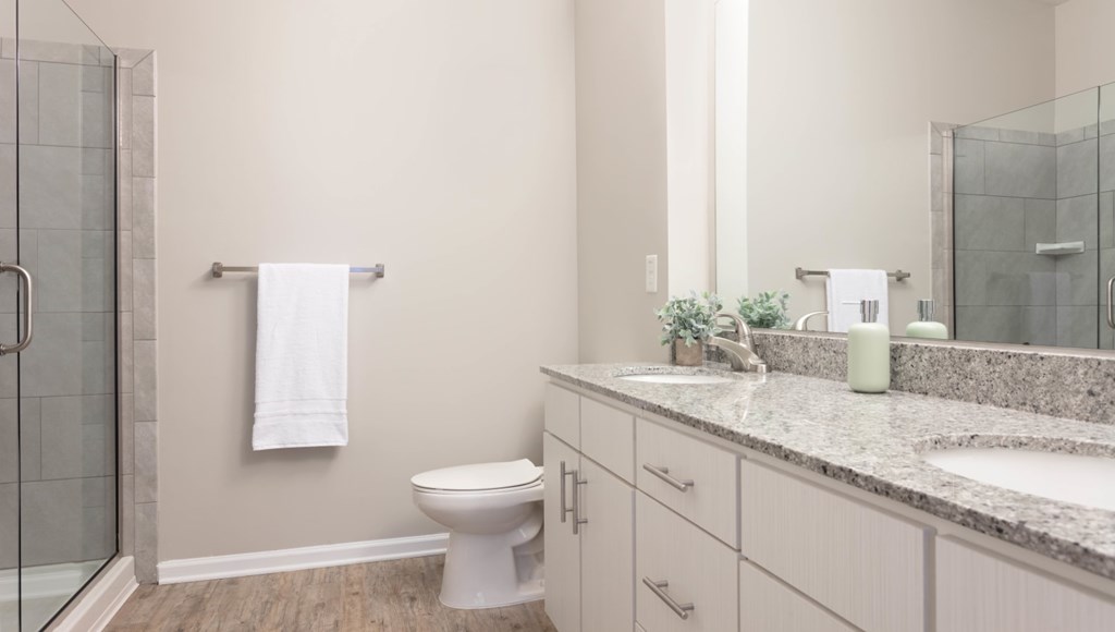 A white toilet sits in a bathroom with a glass shower door.