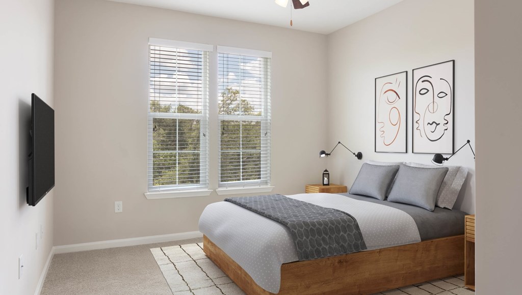 A bedroom with a bed, a television, and a window with blinds.