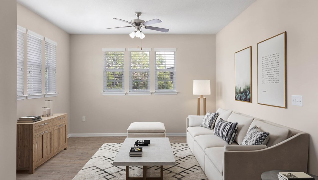 A living room with a couch, a coffee table, and a ceiling fan.