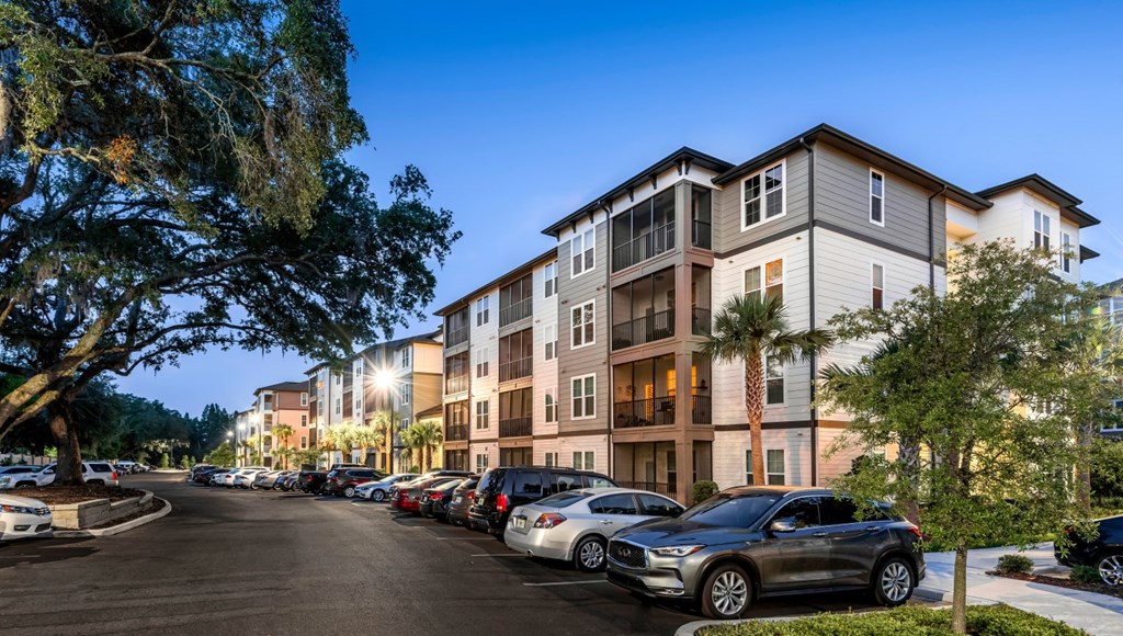 A parking lot with cars and a building in the background.