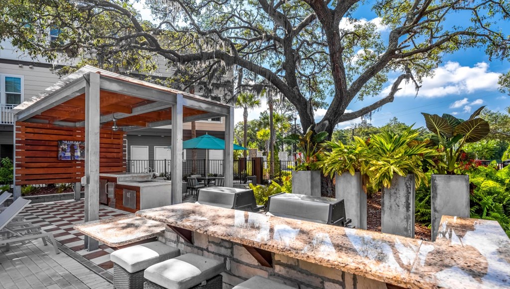 A wooden outdoor kitchen with a grill and sink.