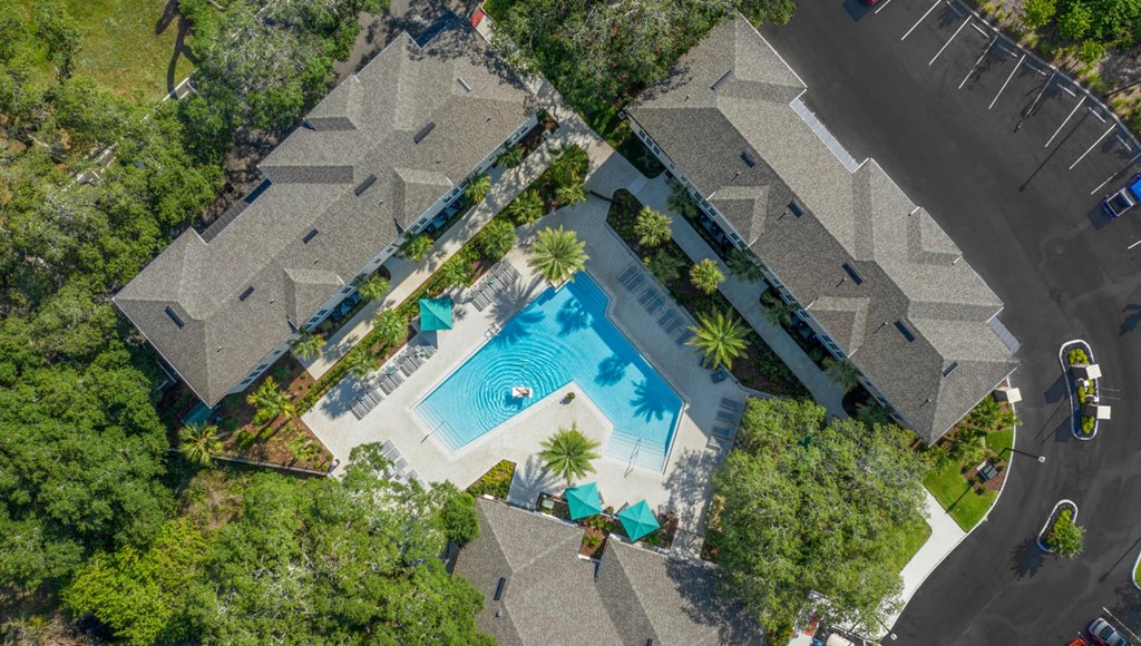 An aerial view of a residential area with houses and a swimming pool.
