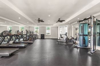 A spacious gym with treadmills, exercise bikes, and weights.