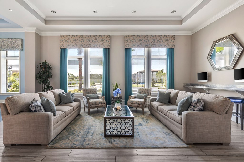 A living room with two couches, a coffee table, and a large window with blue curtains.