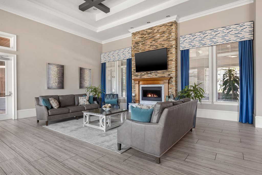 A living room with a grey couch, a fireplace, and a television.