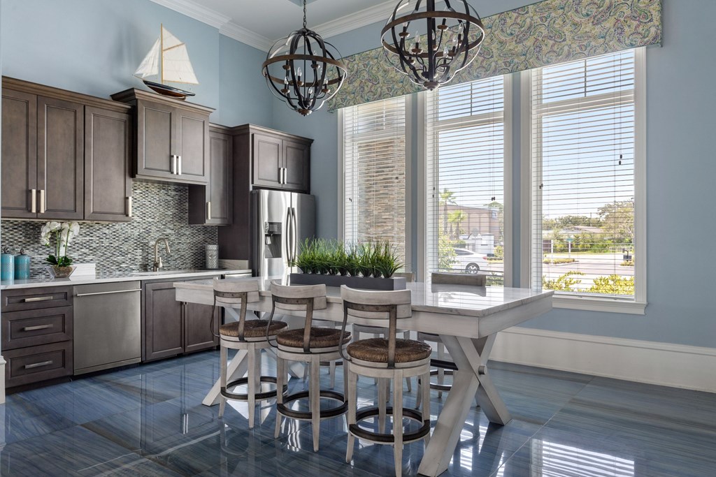A kitchen with a table and chairs in front of a window.